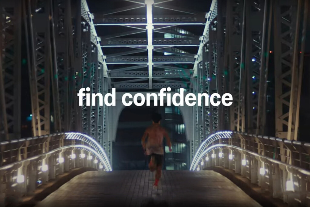 Atleta corre su un ponte illuminato durante la Tokyo Speed Race 5 km, evento ASICS