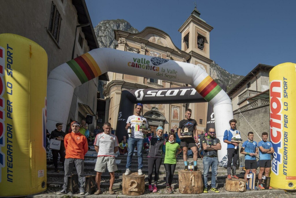 Premiazione di una passata edizione dell’Erbanno Vertical con gli atleti sul podio davanti alla chiesa di Erbanno.