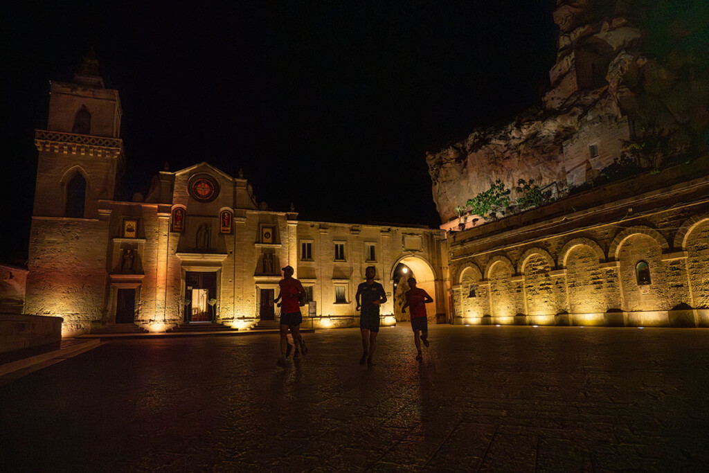 Runner in notturna tra i Sassi di Matera, città patrimonio UNESCO, durante la partenza della Puglia by UTMB 2025.