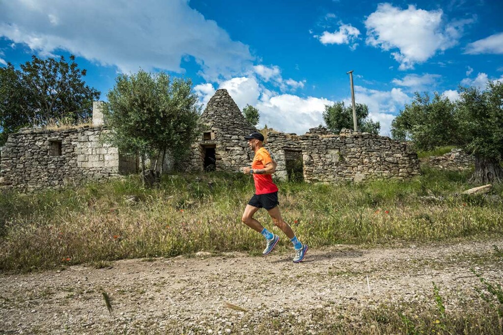 Runner nella Terra delle Gravine durante un allenamento sui sentieri della Puglia, scenario della prima Puglia by UTMB 2025.