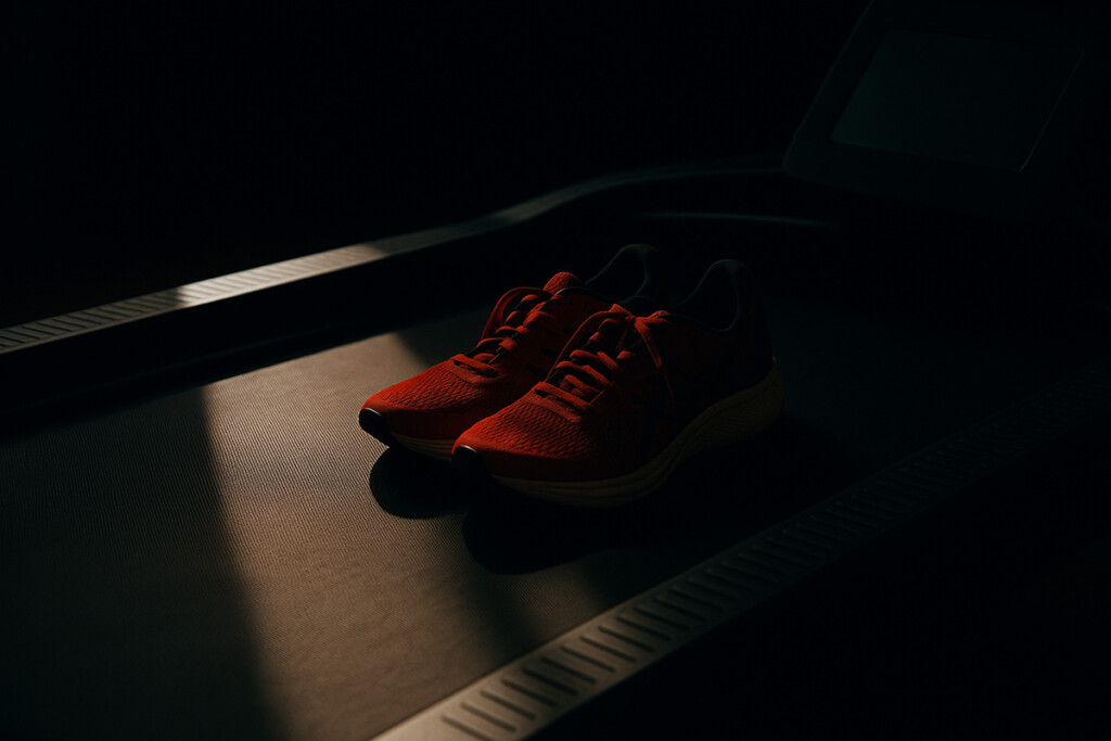 Scarpe da running appoggiate su un tapis roulant spento, simbolo del mondiale virtuale RUN X lanciato da World Athletics e Technogym.