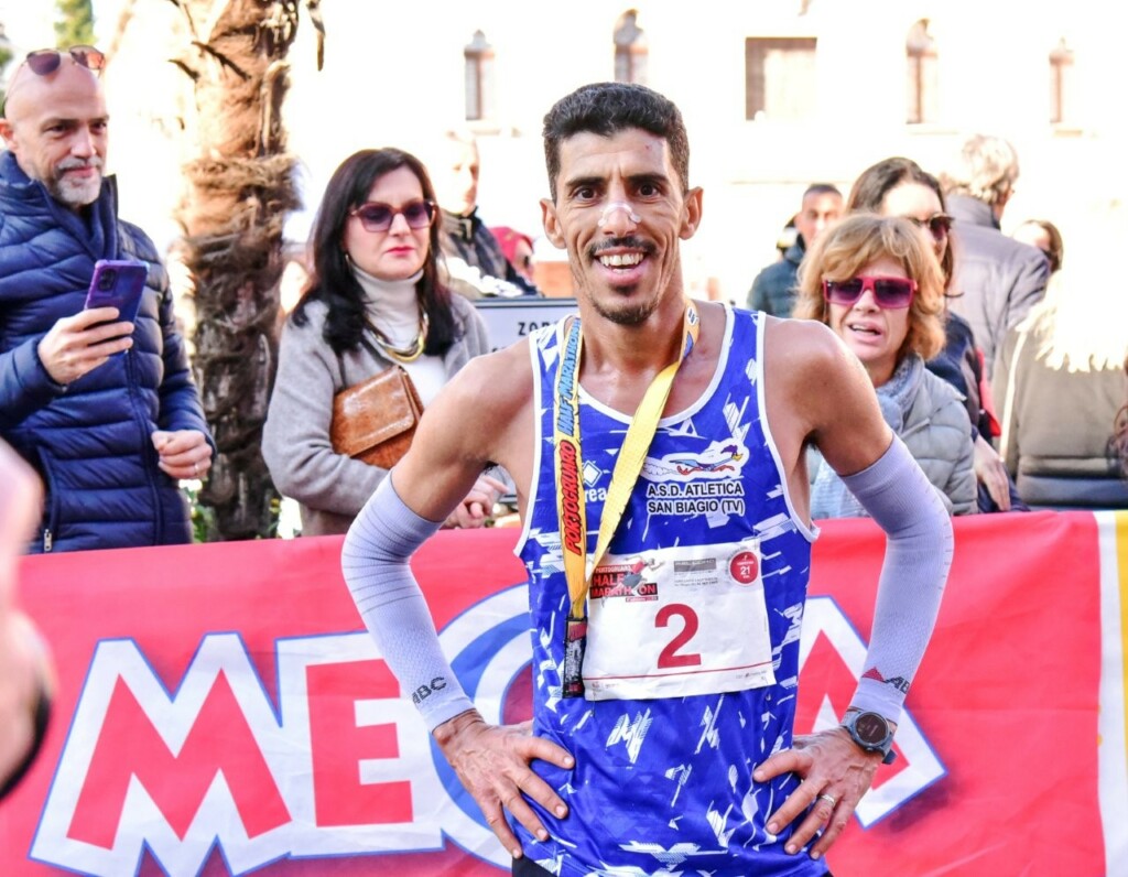 Abdoullah Bamoussa all’arrivo della Portogruaro Half Marathon 2025, con pettorale e medaglia nella zona del traguardo.