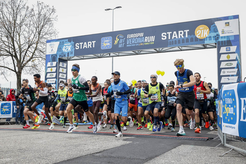 Atleti al via della Verona Marathon 2024 sotto l’arco di partenza della Eurospin Verona Run, con i protagonisti delle distanze 42 km e 21 km pronti a scattare nel cuore della città scaligera.