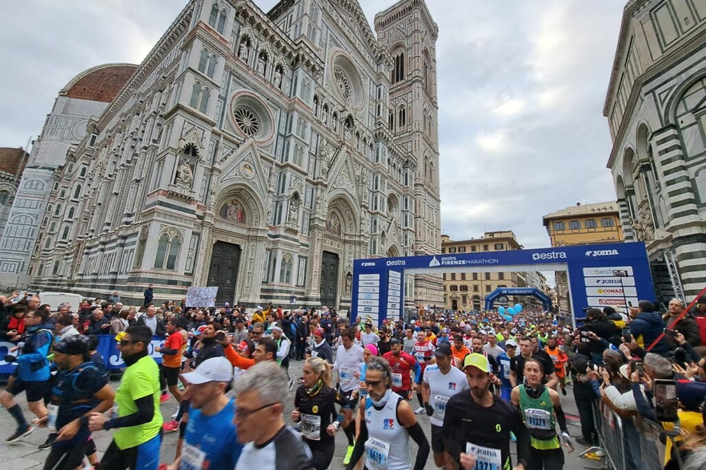 La partenza della Firenze Marathon in Piazza Duomo con centinaia di runner in corsa davanti alla Cattedrale di Santa Maria del Fiore.