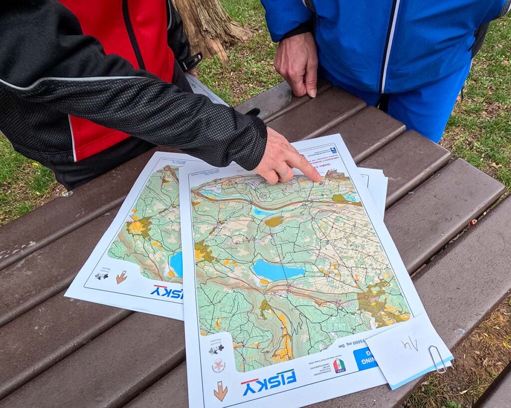 Mani che indicano la mappa di gara utilizzata dagli atleti FISky e dalla rappresentativa FISO durante la SkyRun in Orienteering di Monfalcone 2025.