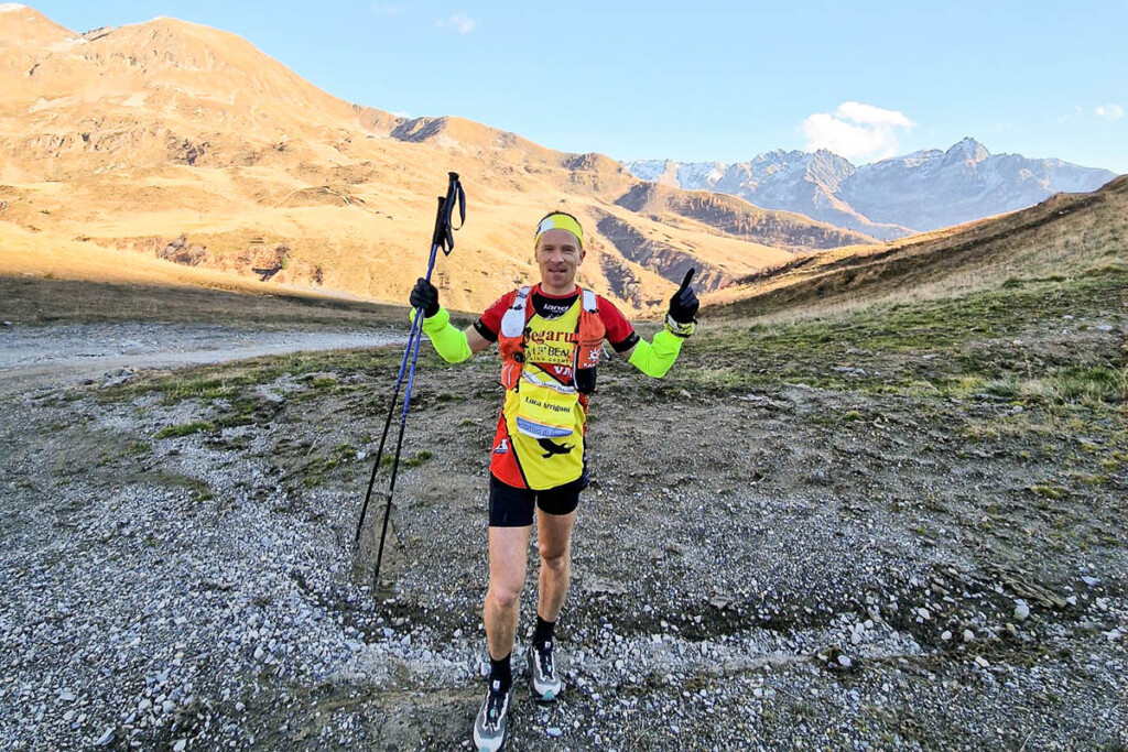 Luca Arrigoni dopo il record sul Sentiero 101 delle Orobie Occidentali, ritratto a Foppolo con le montagne innevate sullo sfondo. Foto di Giorgio Pesenti / Pegarun.
