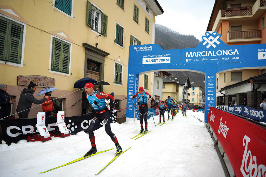 Andreas Nygaard guida il gruppo di testa alla Marcialonga 2025 tra le vie di Predazzo, tappa trentina dello storico evento di sci di fondo tra le valli di Fiemme e Fassa.