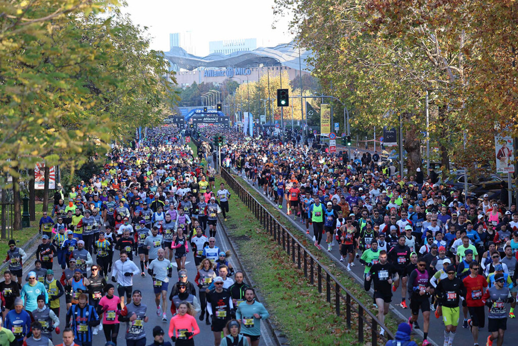 Folla di runner alla partenza della Milano21 Half Marathon 2025 con migliaia di partecipanti in corsa su viale Boezio verso il MiCo Allianz.