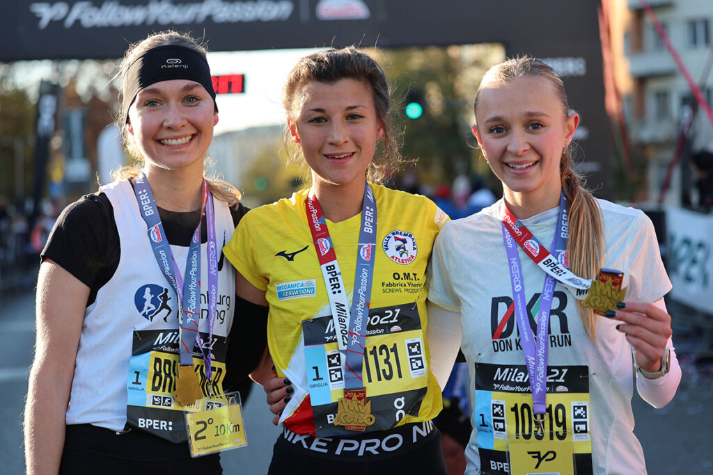 Lea Brückner, Cristina Molteni e Camilla Galimberti posano sorridenti al traguardo dopo il podio femminile della 10 km alla Milano21 Half Marathon 2025.