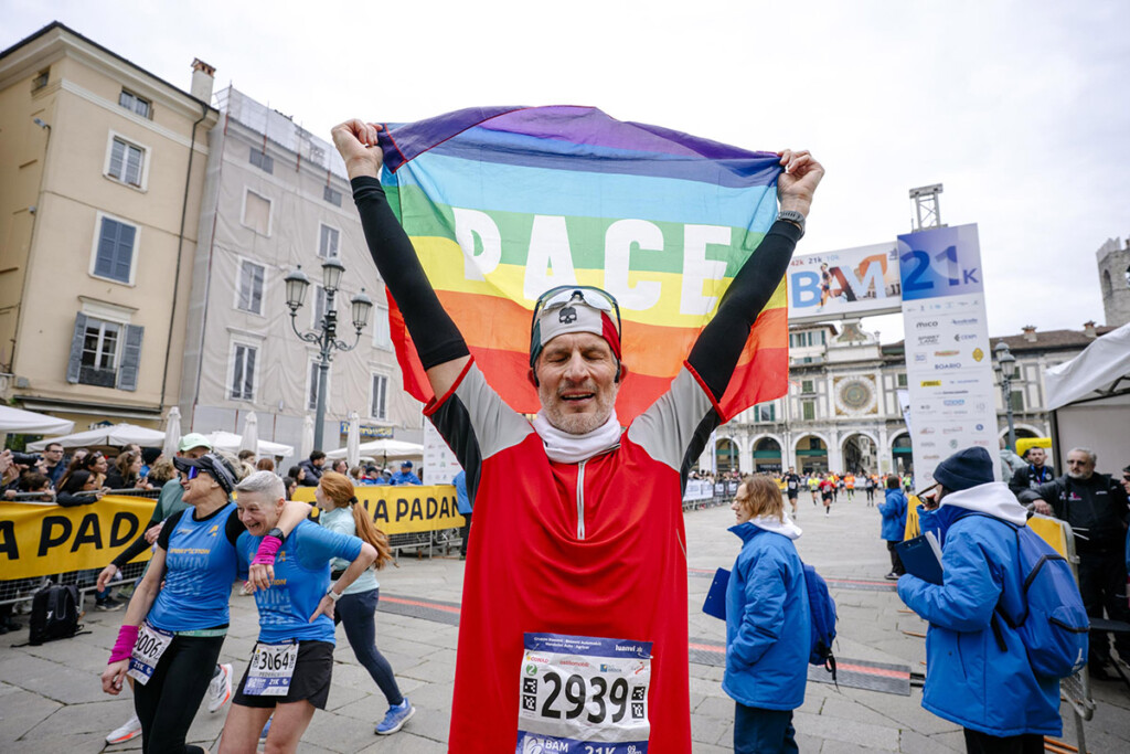Atleta al traguardo della Brescia Art Marathon con la bandiera della pace