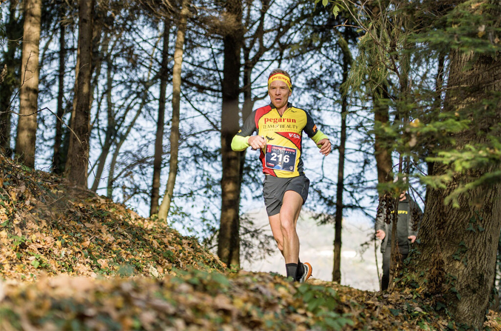 Luca Arrigoni vincitore del Monte Misma Xmas Trail 2025 in discesa nel bosco lungo il percorso di gara, con pettorale e maglia del team, durante l’evento di Villa di Serio.
