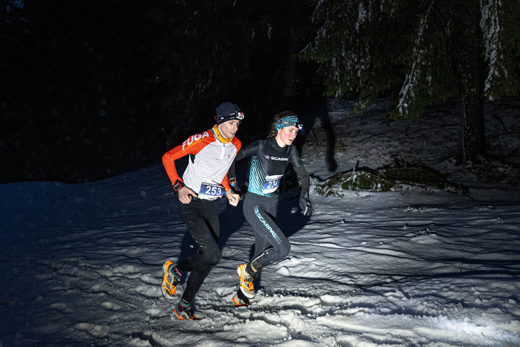Anna Hofer in azione nella SkySnow Schia Monte Caio 2026 durante un tratto notturno sulla neve nel bosco.