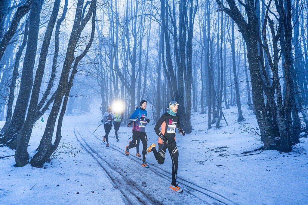 Emanuele Manzi al comando nella SkySnow Schia Monte Caio 2026, in azione nel bosco innevato durante la gara notturna.